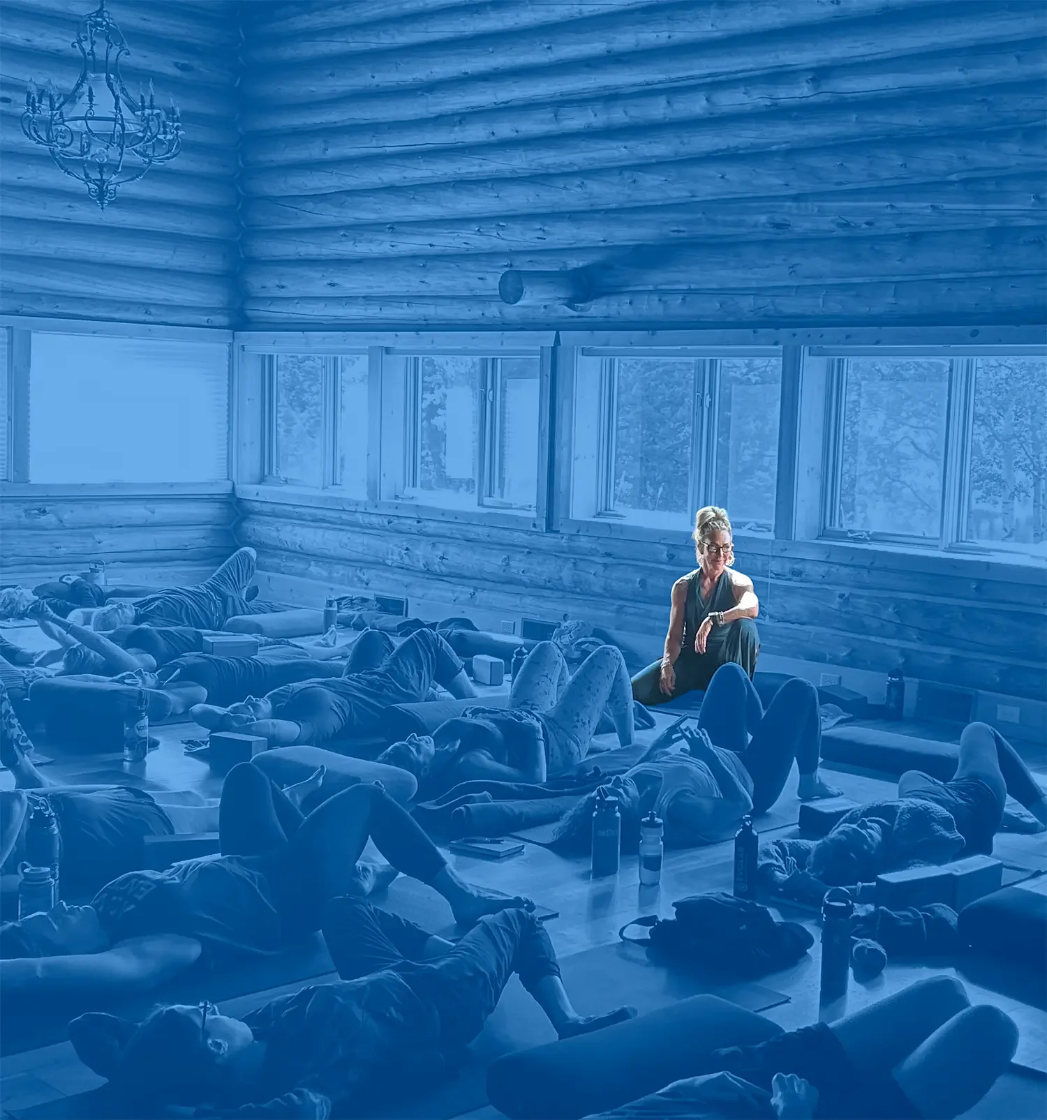 Lisa Fierer leading a group workshop session in a sunlit studio, participants lying on yoga mats.