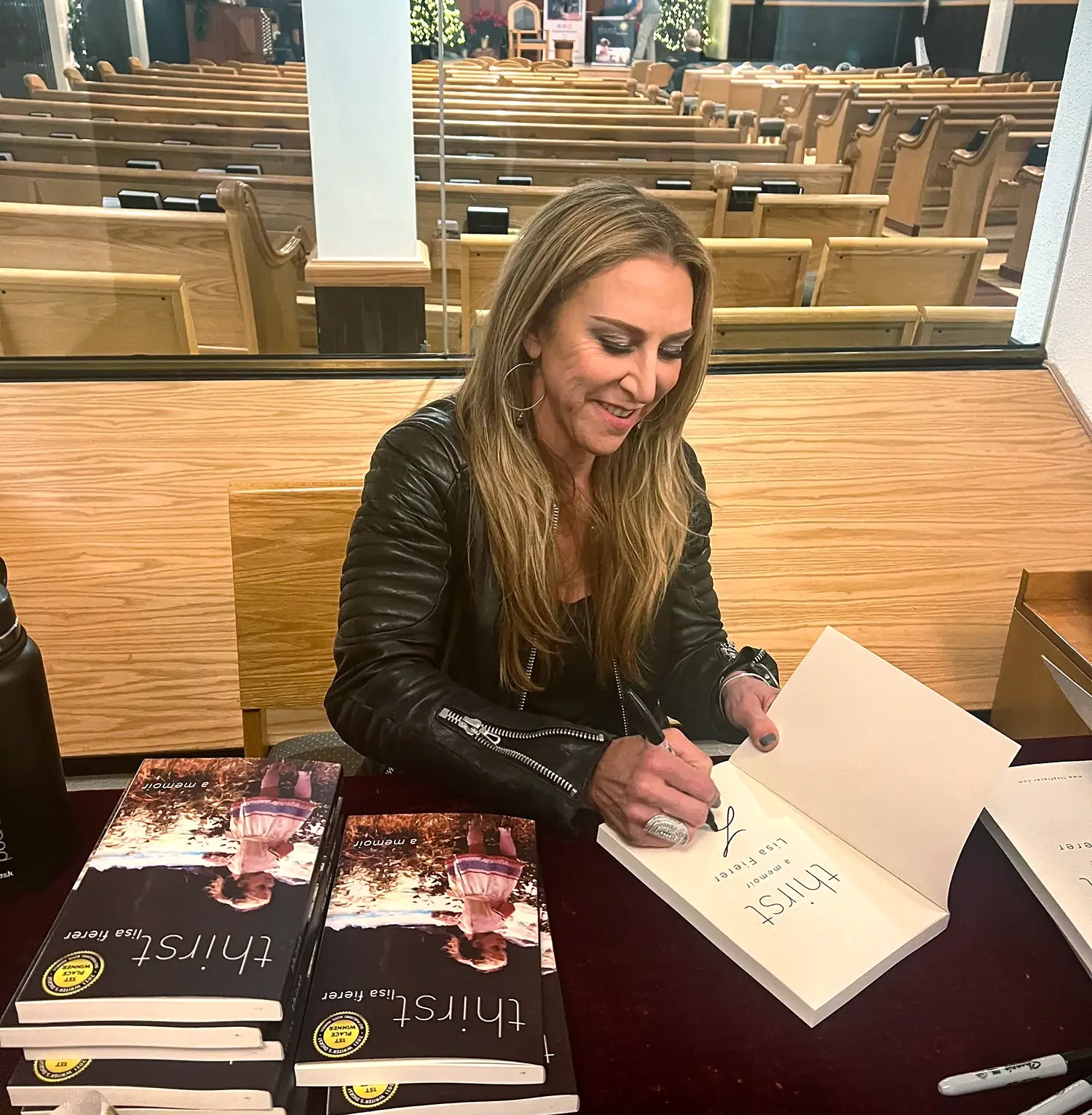 Lisa Fierer signing copies of her memoir Thirst at a book event.