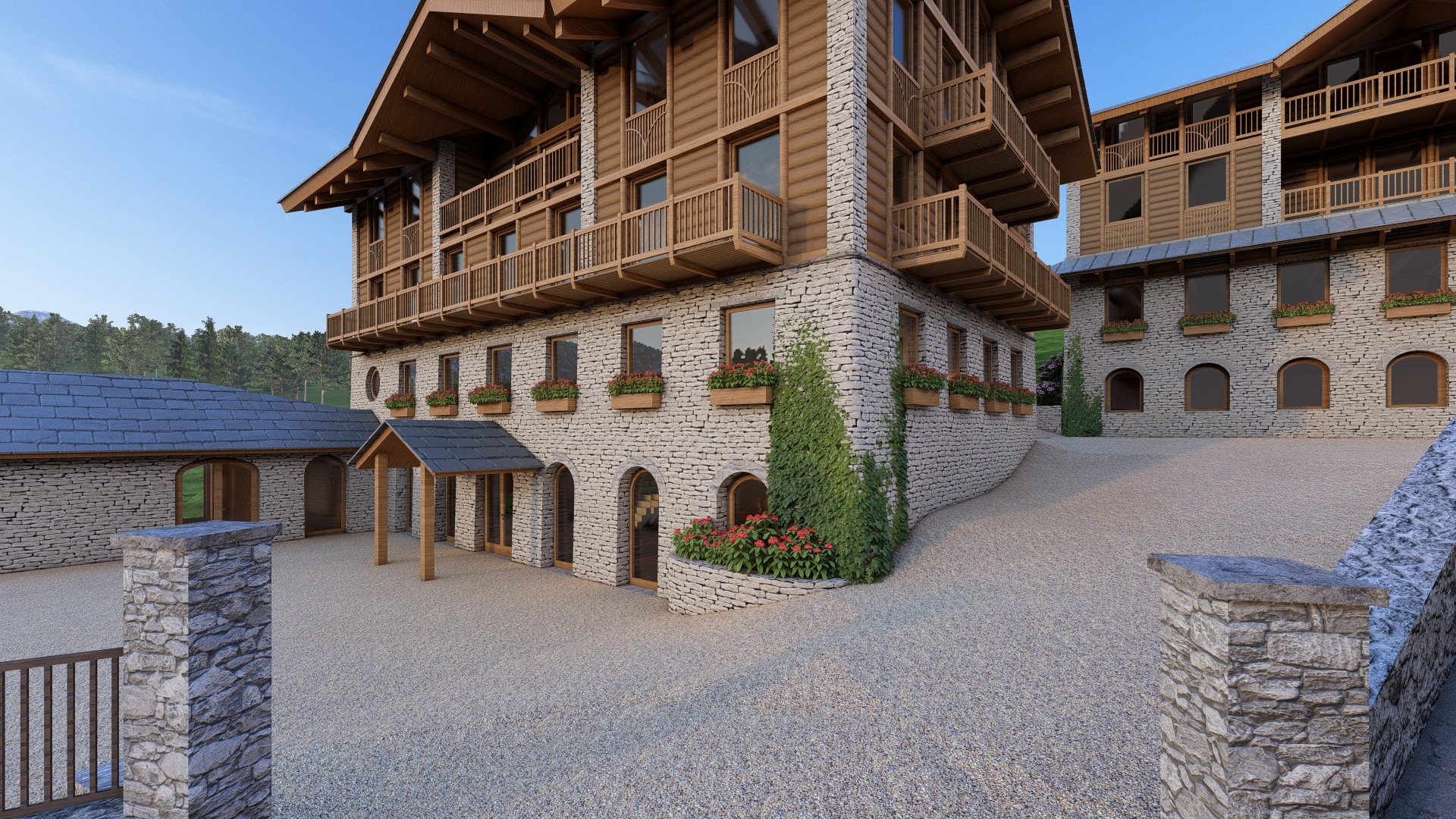 A stone and wood multi-story building with glass doors, small balconies, and flower boxes, surrounded by a gravel courtyard and stone pillars, with trees in the background under a blue sky.