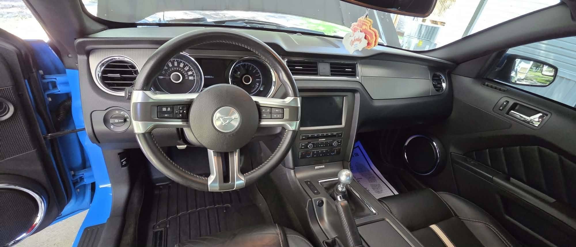 Interior of a modern sports car showing steering wheel, dashboard, gear shift, and front seats.