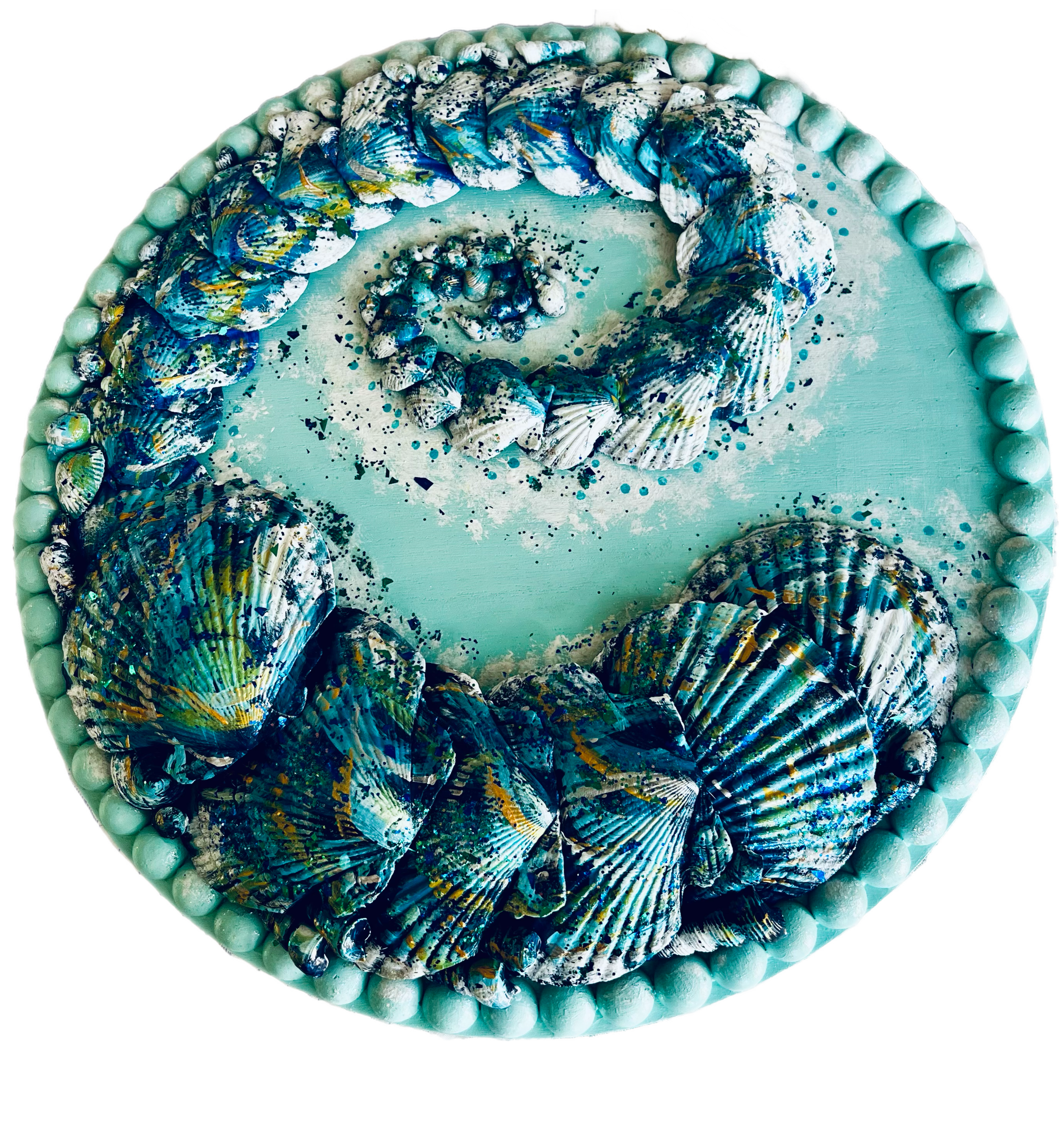 Sea-themed cake decorated with seashell-shaped confections and pearl-like border.