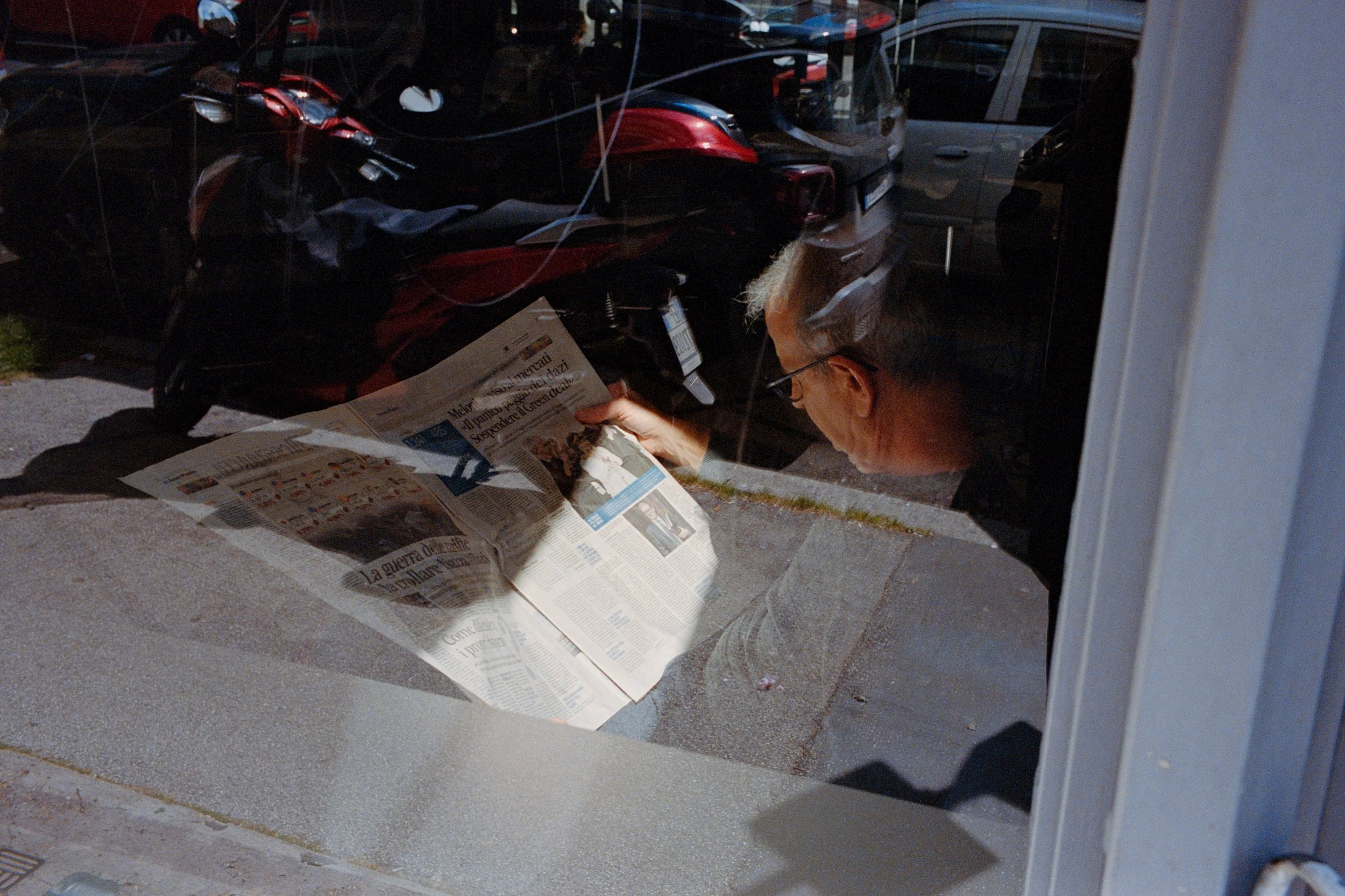 street-photography-italy-yanis-machonis-man-reading-newspaper-reflection.jpg