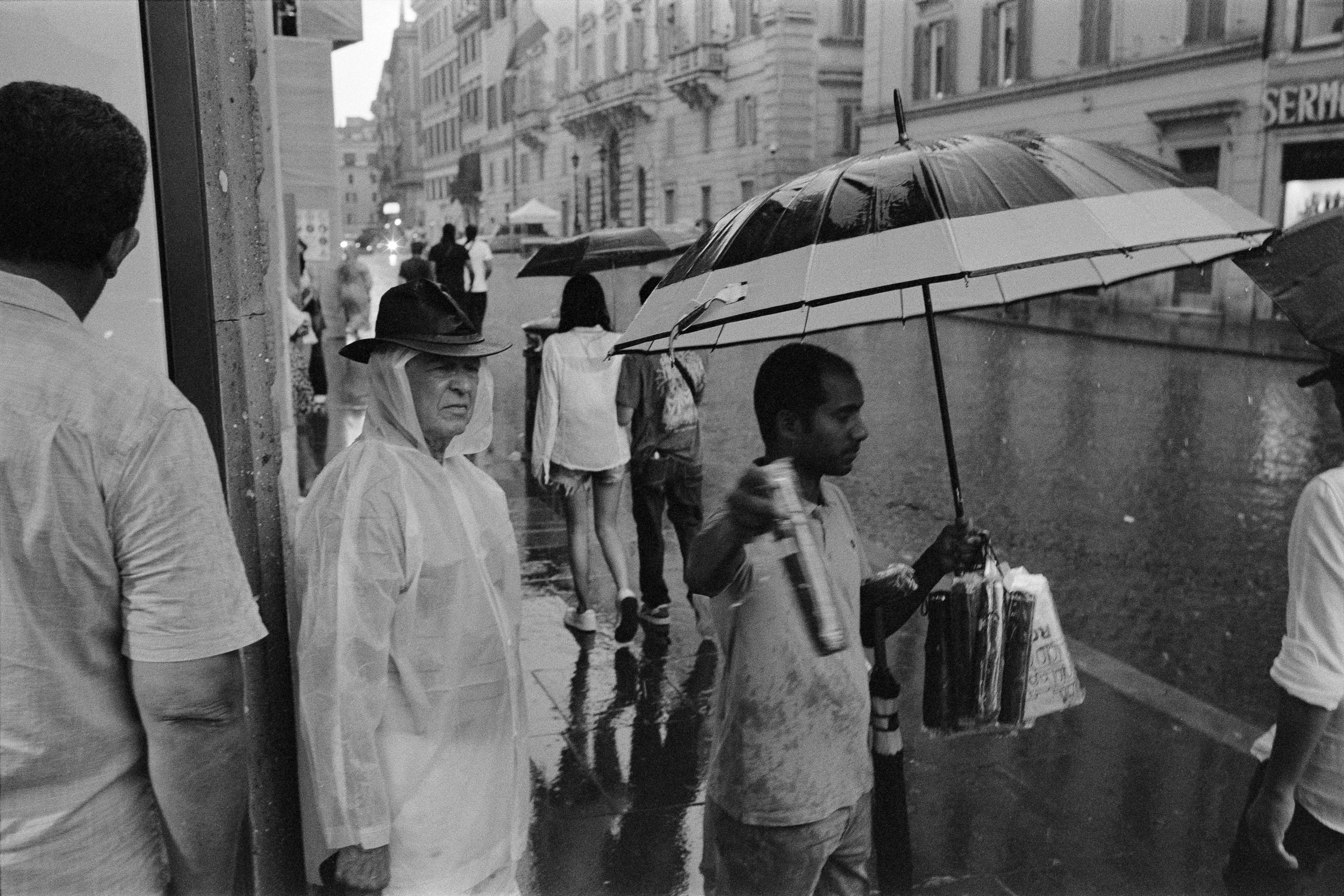 street-photography-italy-yanis-machonis-street-vendor-in-rain-bw.jpg