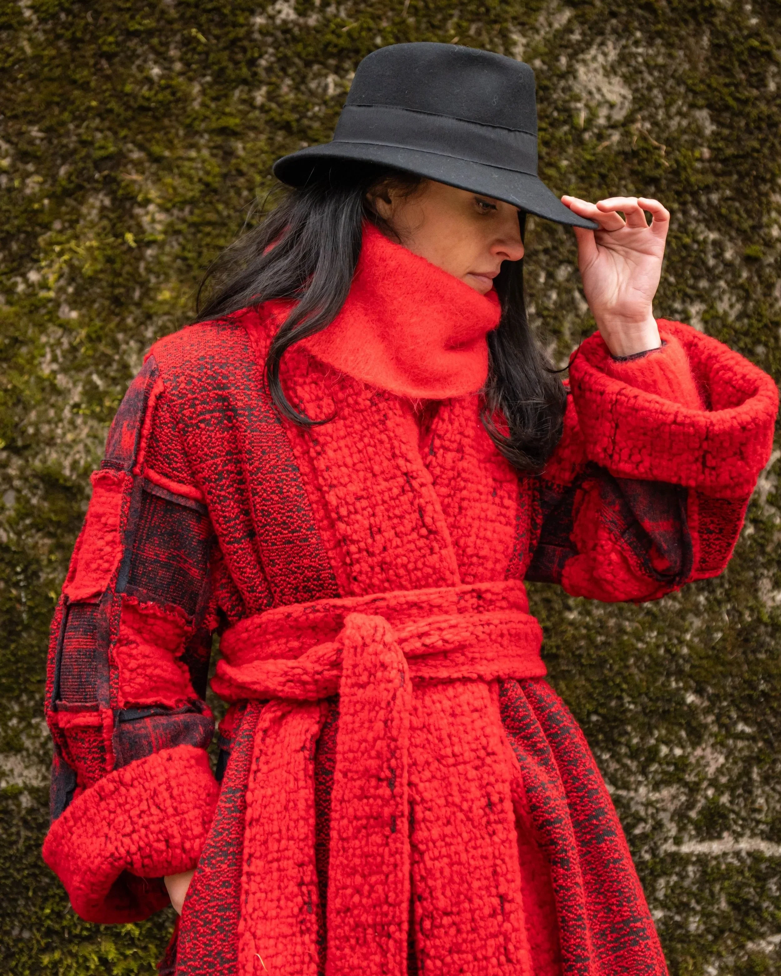 Donna con cappello nero e cappotto rosso 