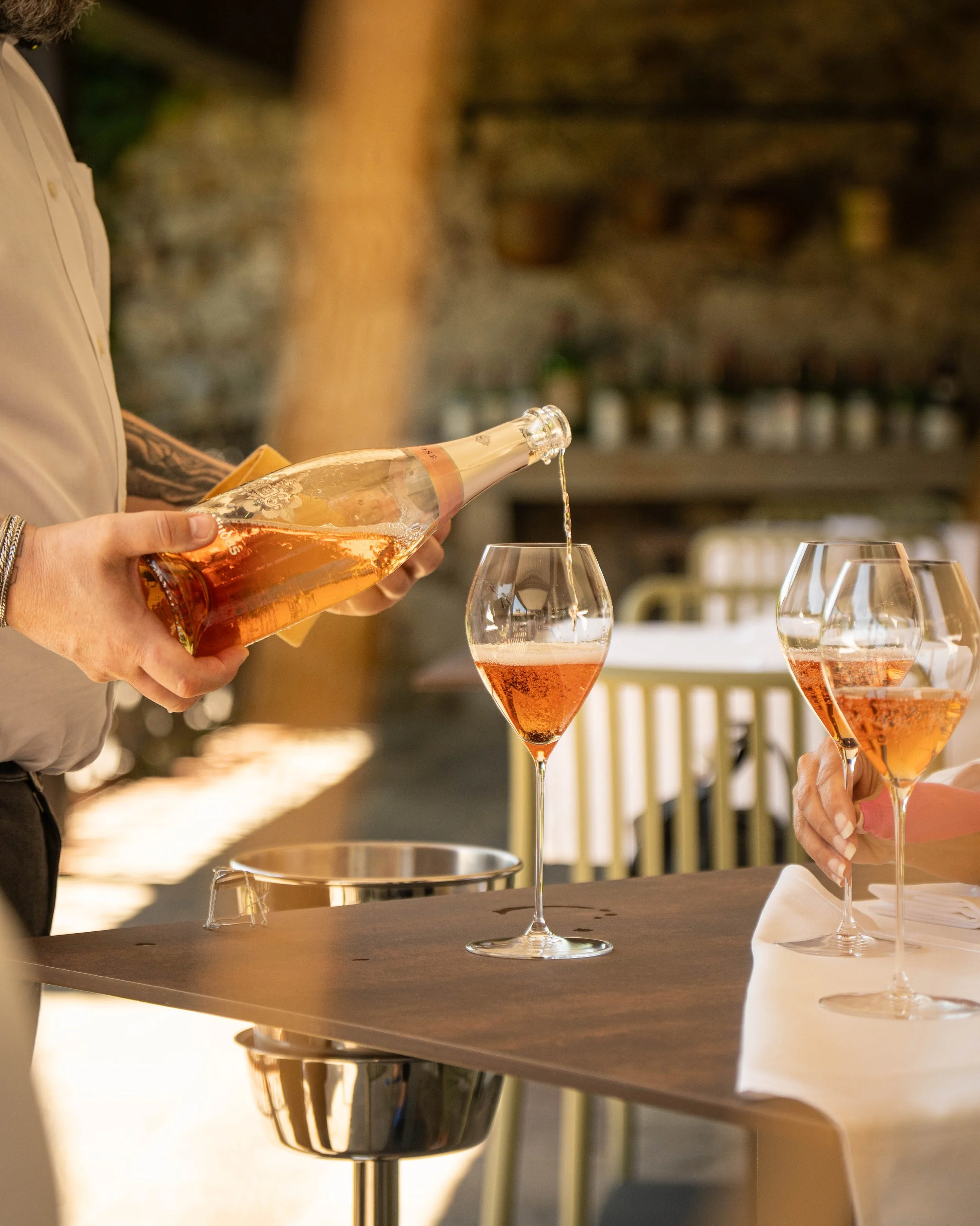 sommelier che versa del vino in un bicchiere nella terrazza del suo ristorante