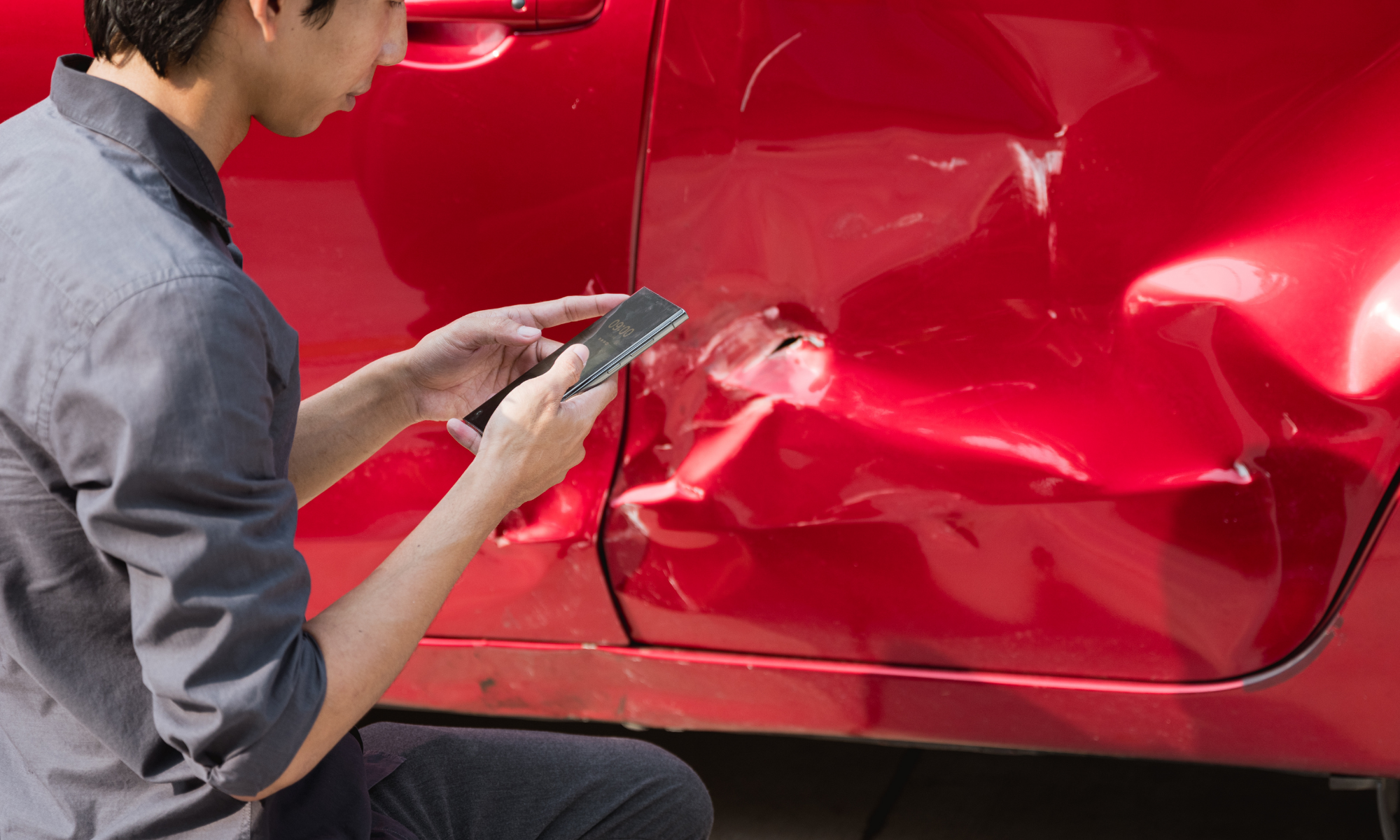 Driver documenting vehicle damage after a car accident in Arizona