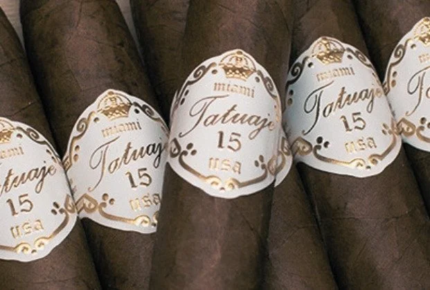 Four cigars with white and gold labels reading "Miami Tatuaje 15 USA."