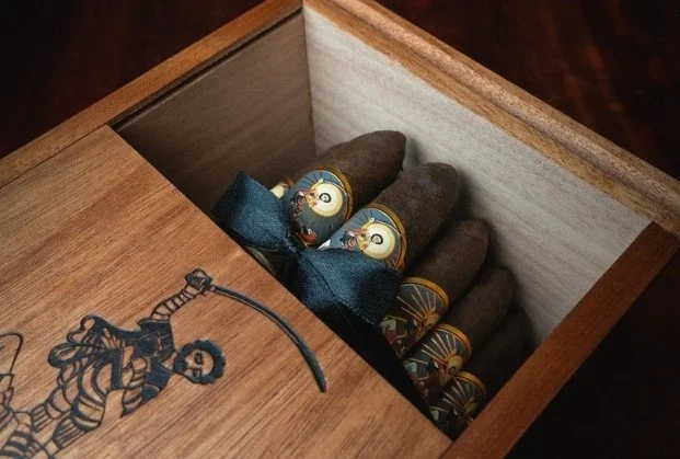 Inside a wooden box, there are five cigars with luxury wrapping.