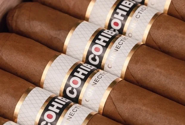 Multiple cigars with a band that reads 'Cohiba' and 'Connecting'.