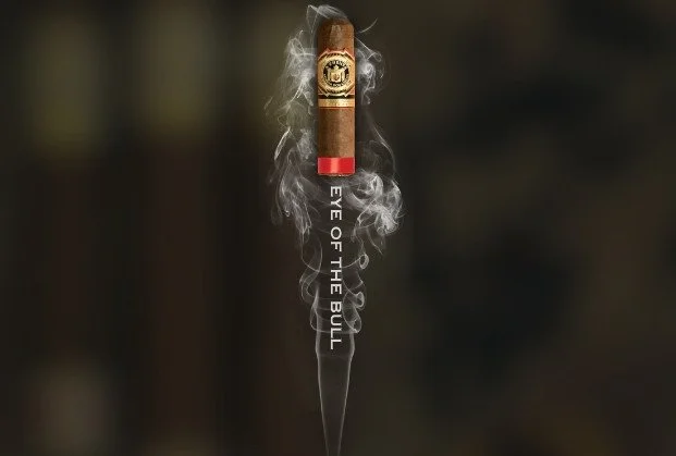 A cigar with smoke forming the words "EYE OF THE BULL".