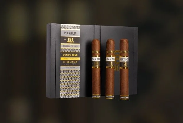 Three cigars placed on a black hardcover book titled 'Plasencia'.