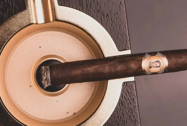 A cigar resting on a vintage record player turntable.