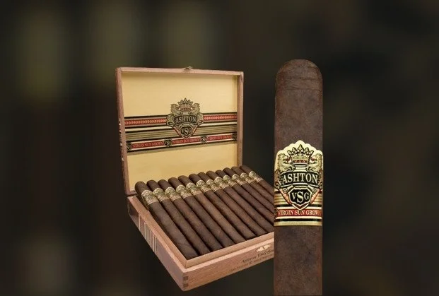 Open wooden box with cigars and a single cigar with a label beside it.