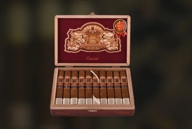 Open box of cigars with ornate label inside the lid, featuring a red and gold design, and a seal in the top right corner indicating award recognition.