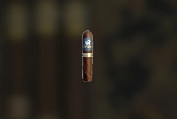 A cigar floating in mid-air in front of a blurred background.