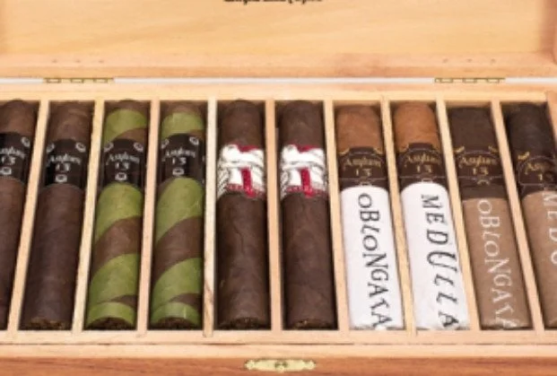 A wooden box containing several cigars with different bands and labels.