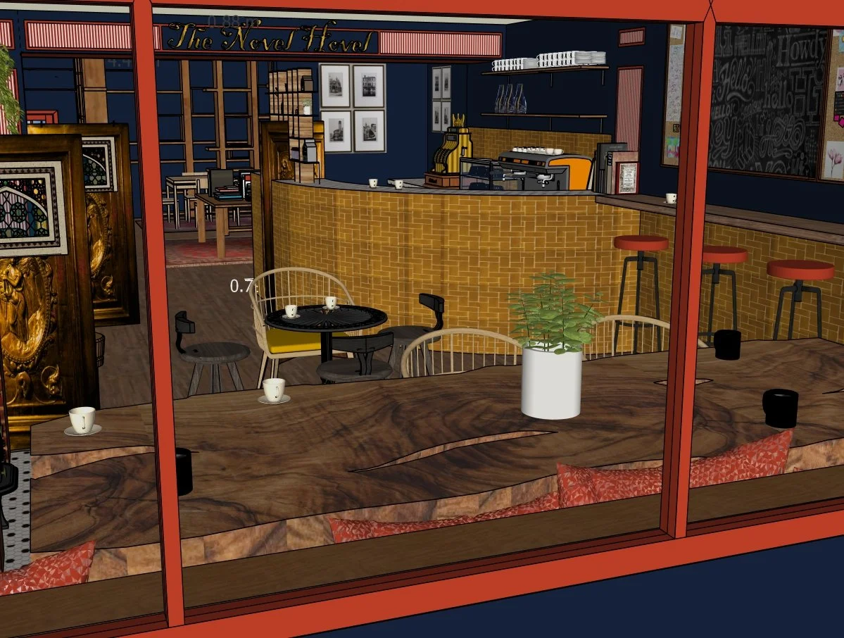 Inside view of a cozy cafe with a wooden table in foreground, a potted plant, and a bar with barstools in the background, featuring a coffee machine and books behind the counter.