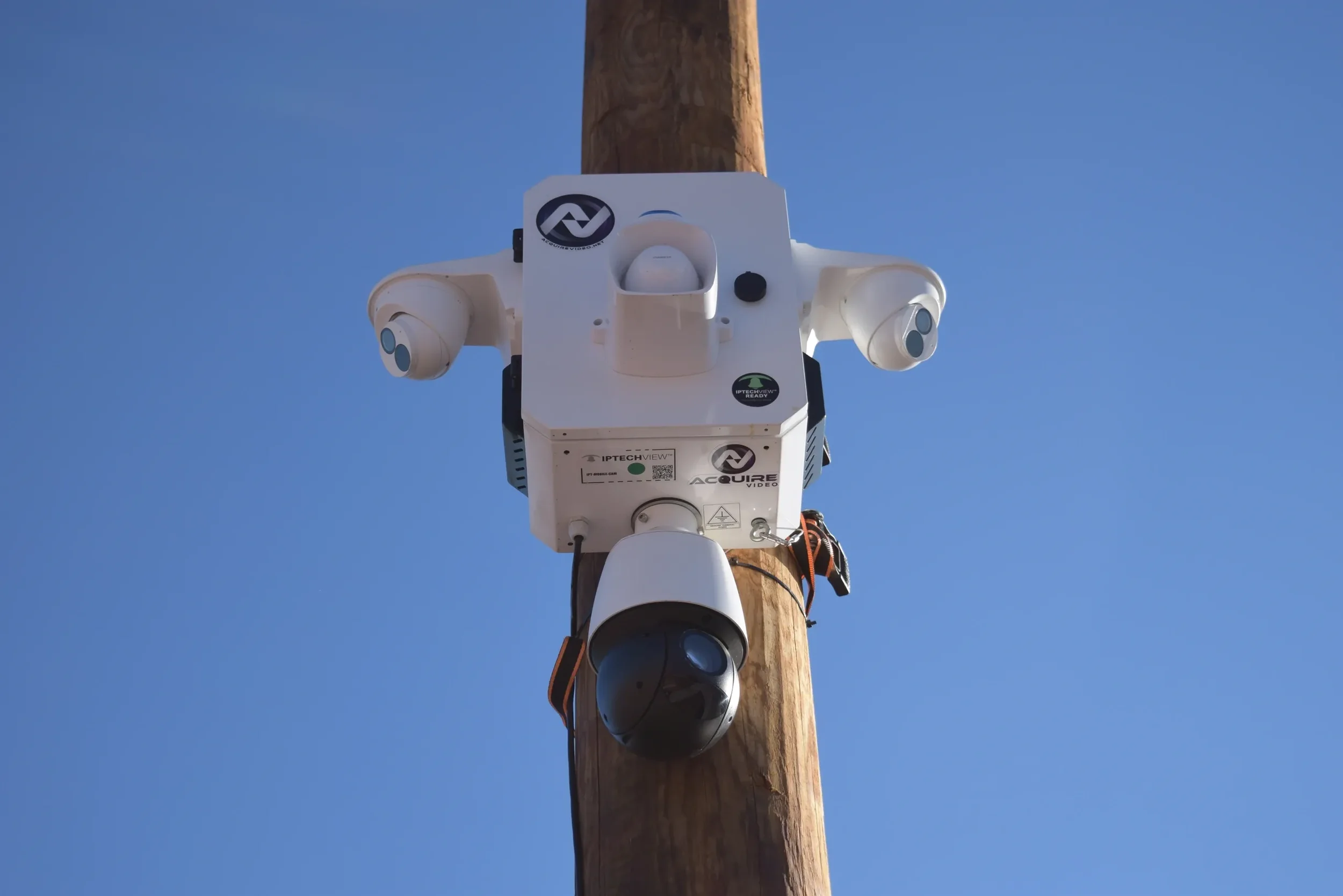 A pole with SiteSight camera mounted on it, set against a blue sky.