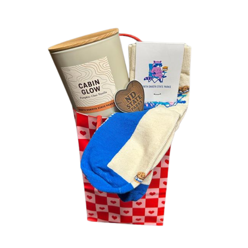 Cabin Glow scented candle with blue and tan socks in red checkered pouch