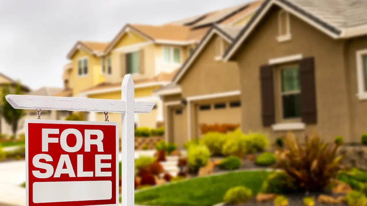 Residential houses with a for sale sign in front.