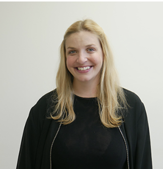 A young woman with long blonde hair smiling at the camera, wearing a black top and black jacket against a plain white background.
