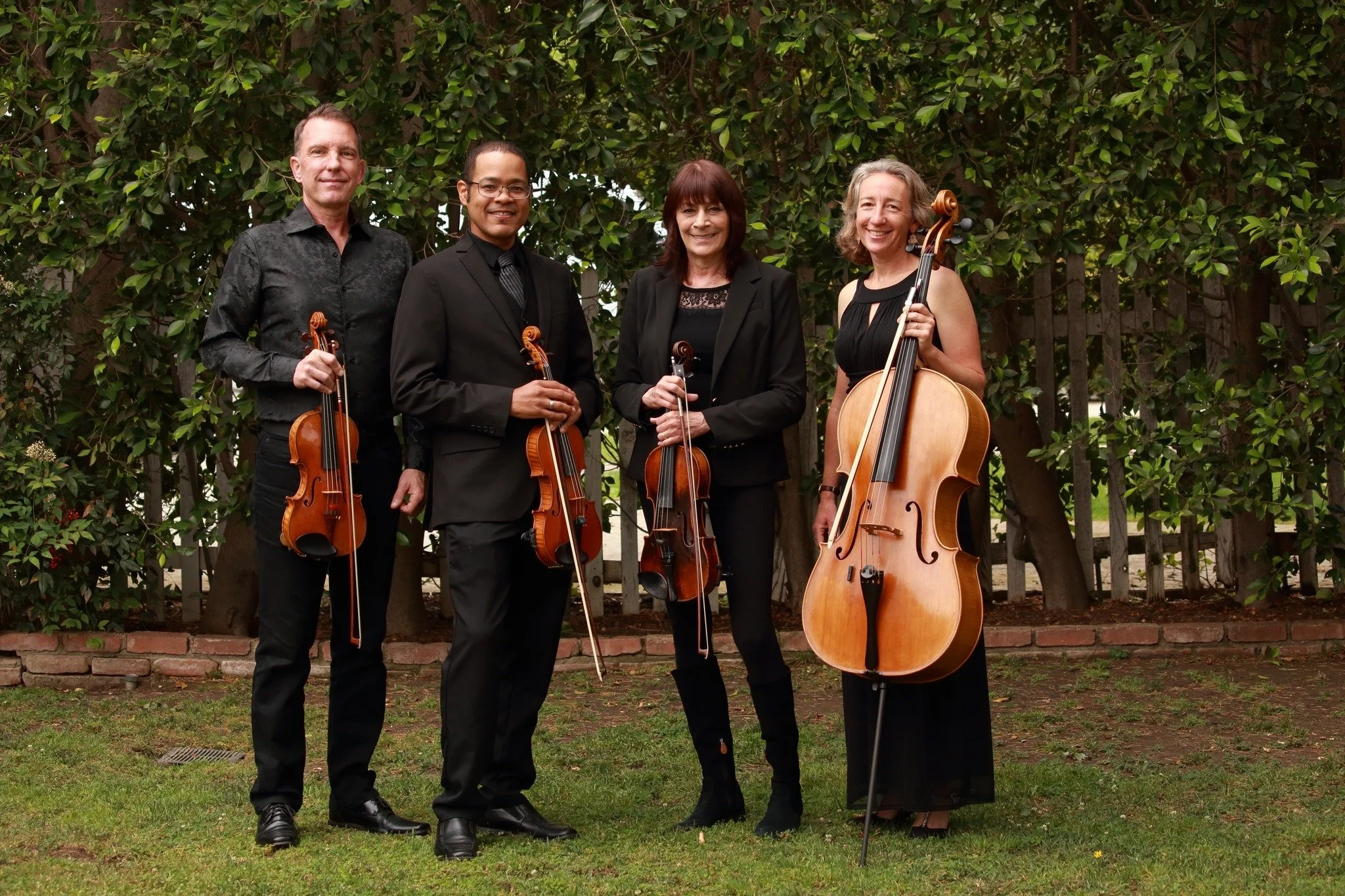 Kadima String Quartet in front of green leafy background