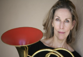 A woman with blonde hair holding a red and gold plate.