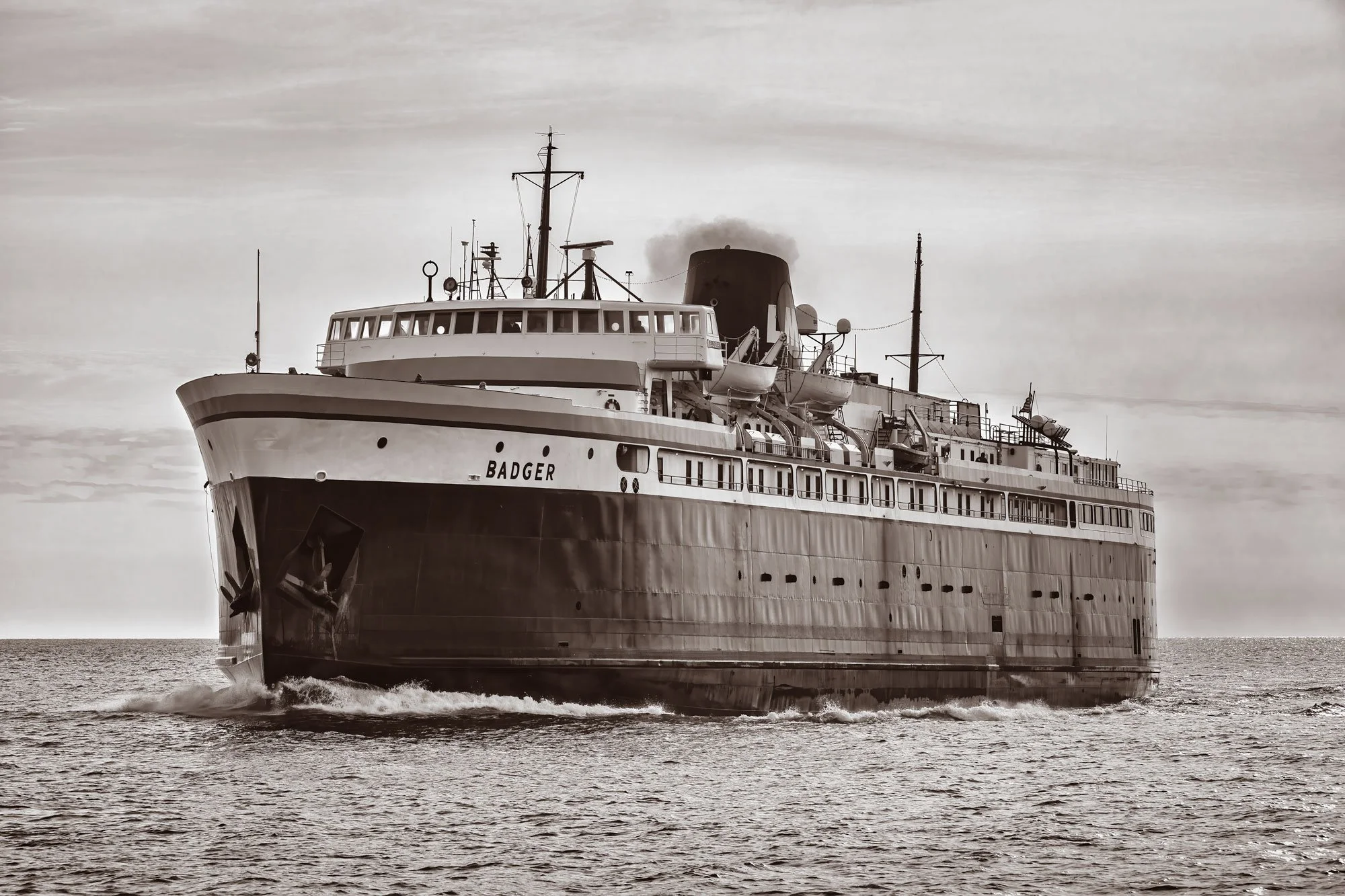 A large ship named Badger sailing on Lake Michigan, black and white photo.