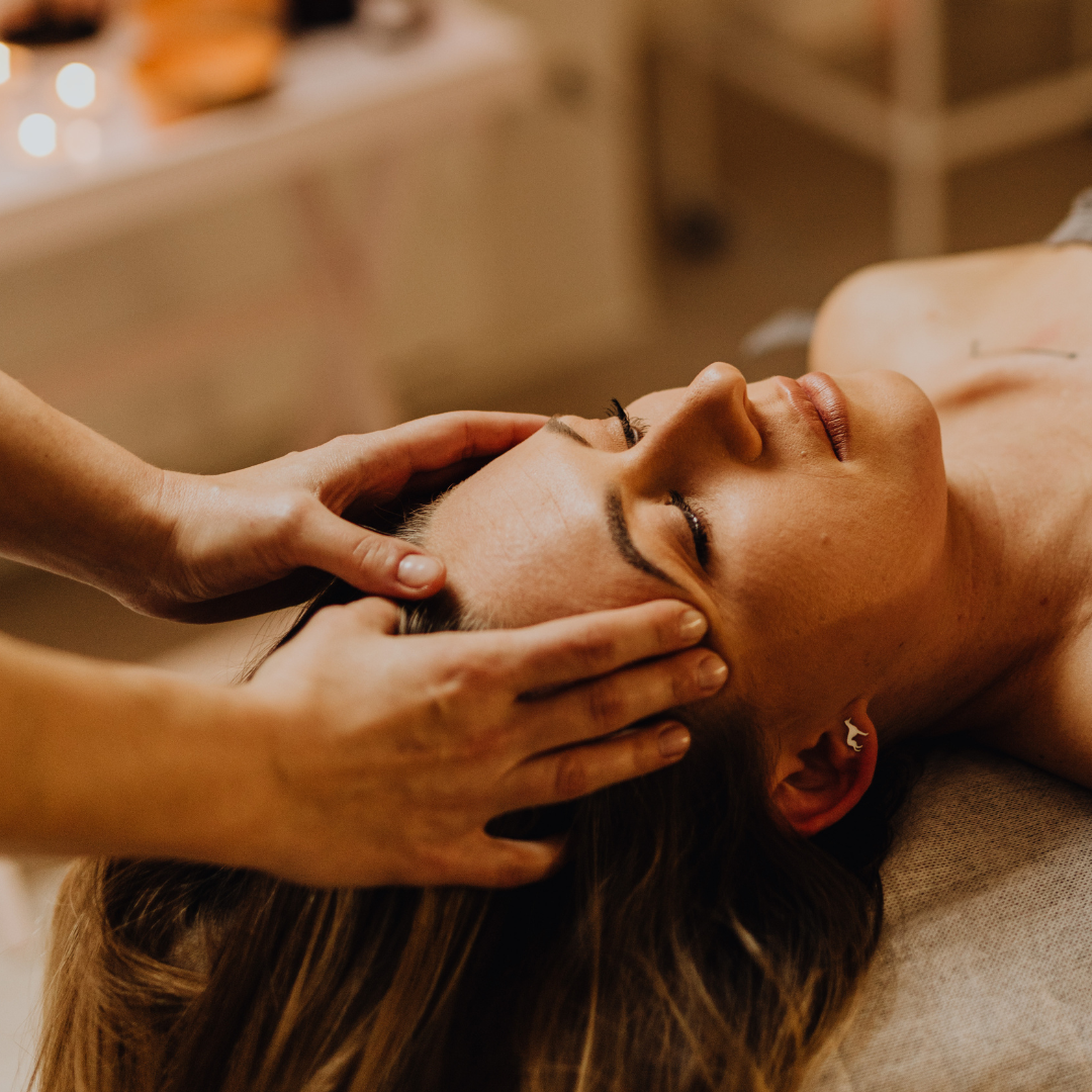 A woman receiving a head massage or scalp treatment at a spa.