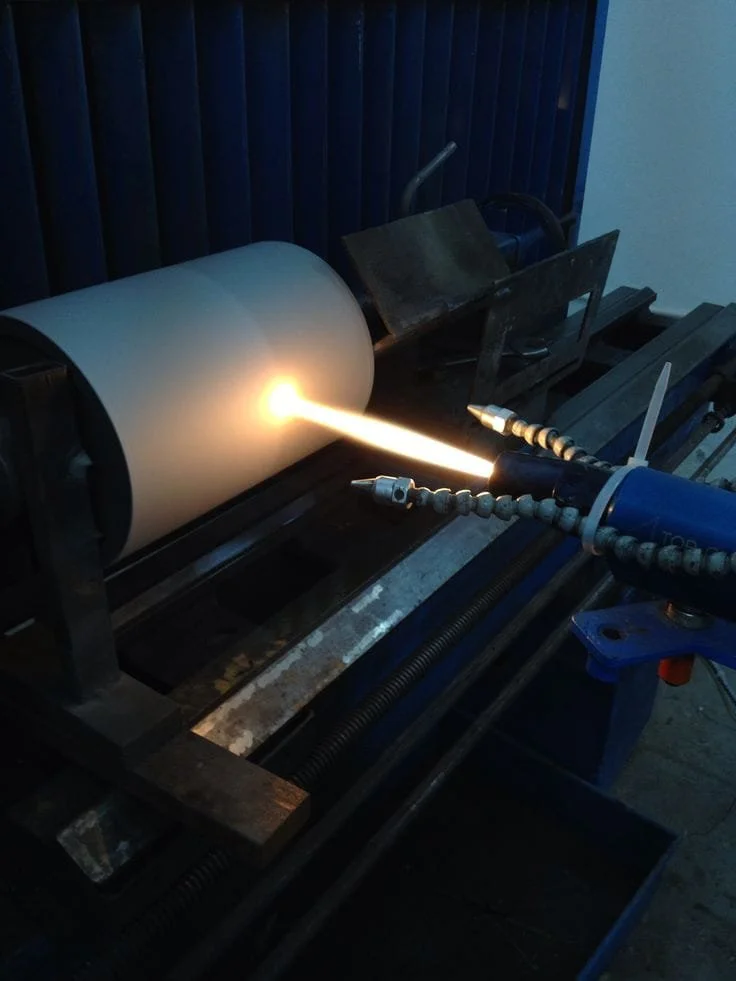 A cylindrical object being coated with HVOF