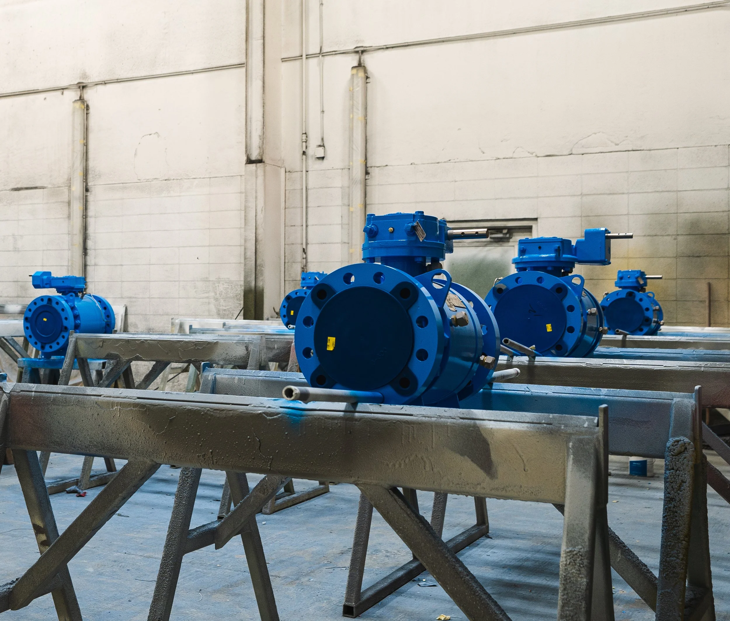 Industrial warehouse with large blue valves and pipes with a coat of liquid-based epoxy coating.
