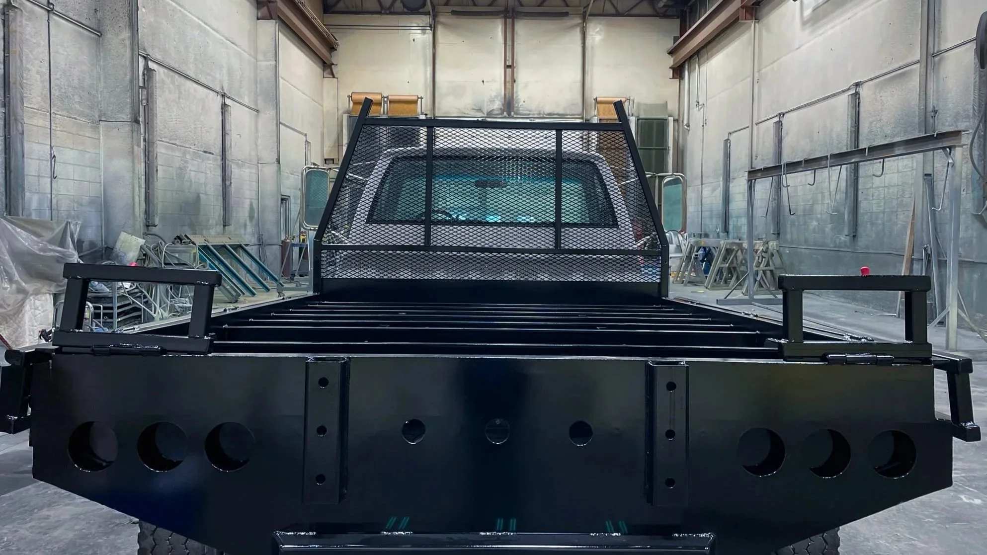Front view of a black flatbed utility vehicle with powder coating.