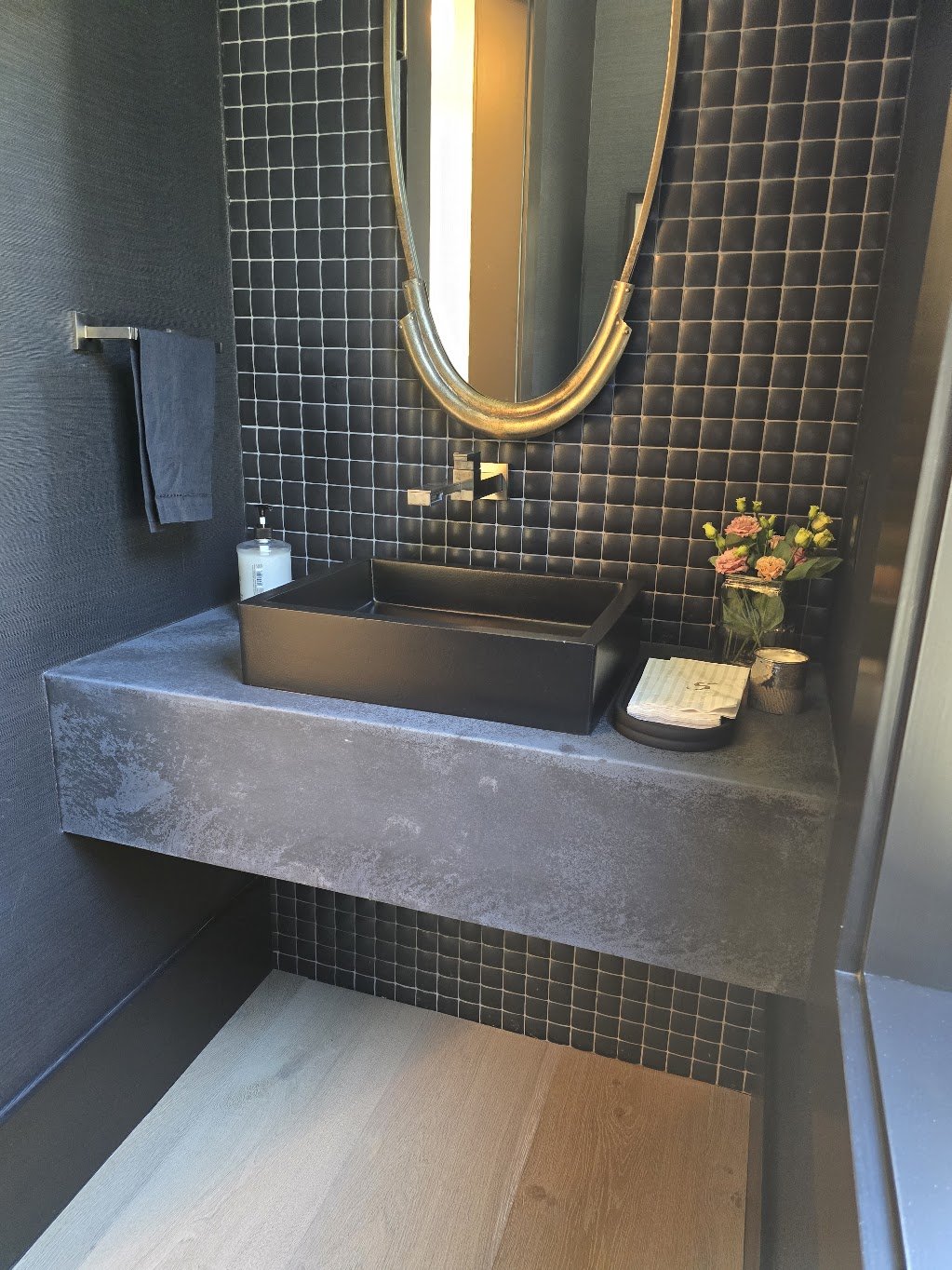 Black vessel sink above a built-in Jetty Stone Dark drop-edge counter