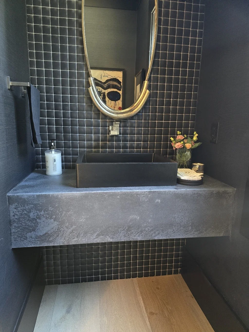 Front view showing the cast variation in the Jetty Stone Dark countertop beneath a black vessel