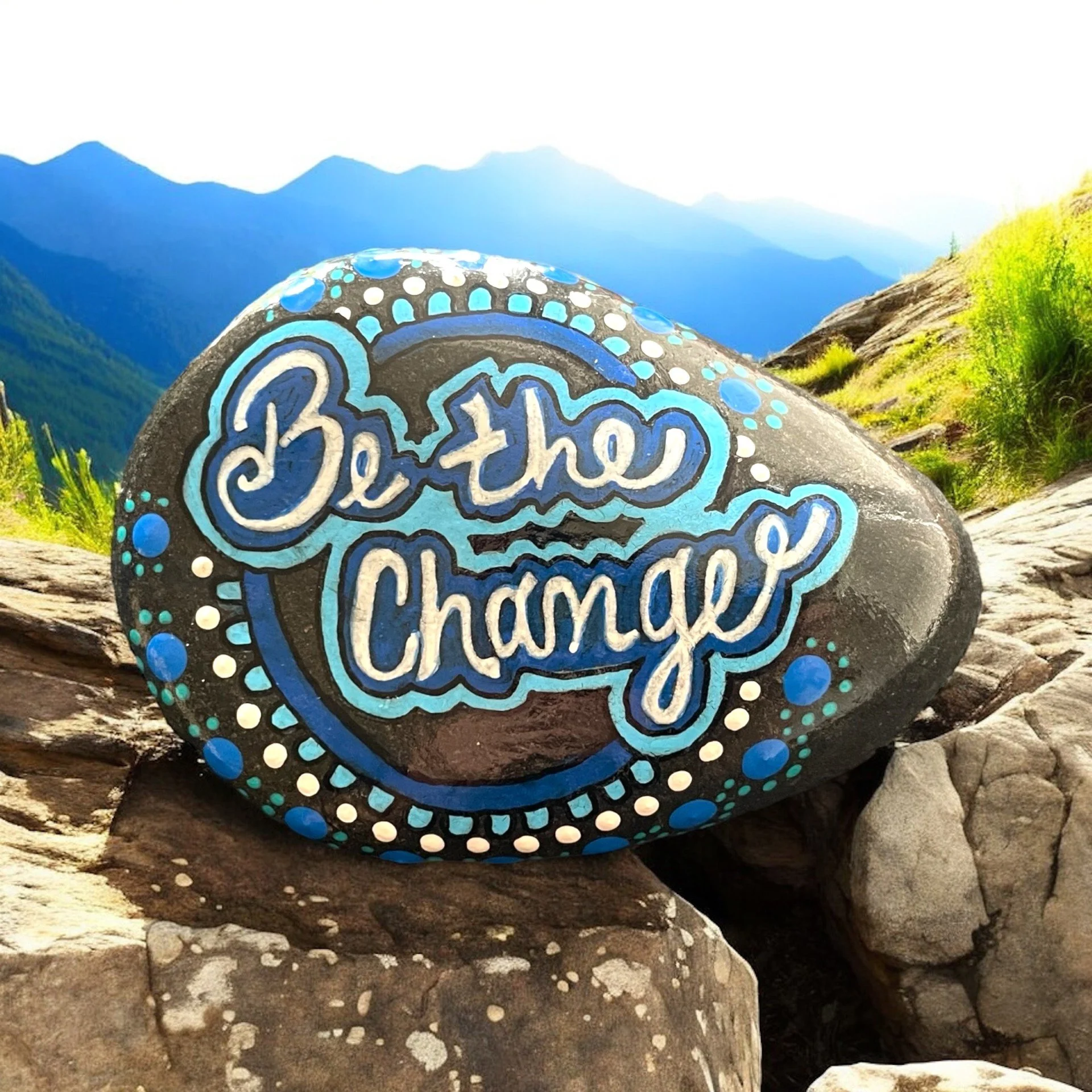 Rock with "Be the Change" painted on in acrylic paint and dot art used for the border.