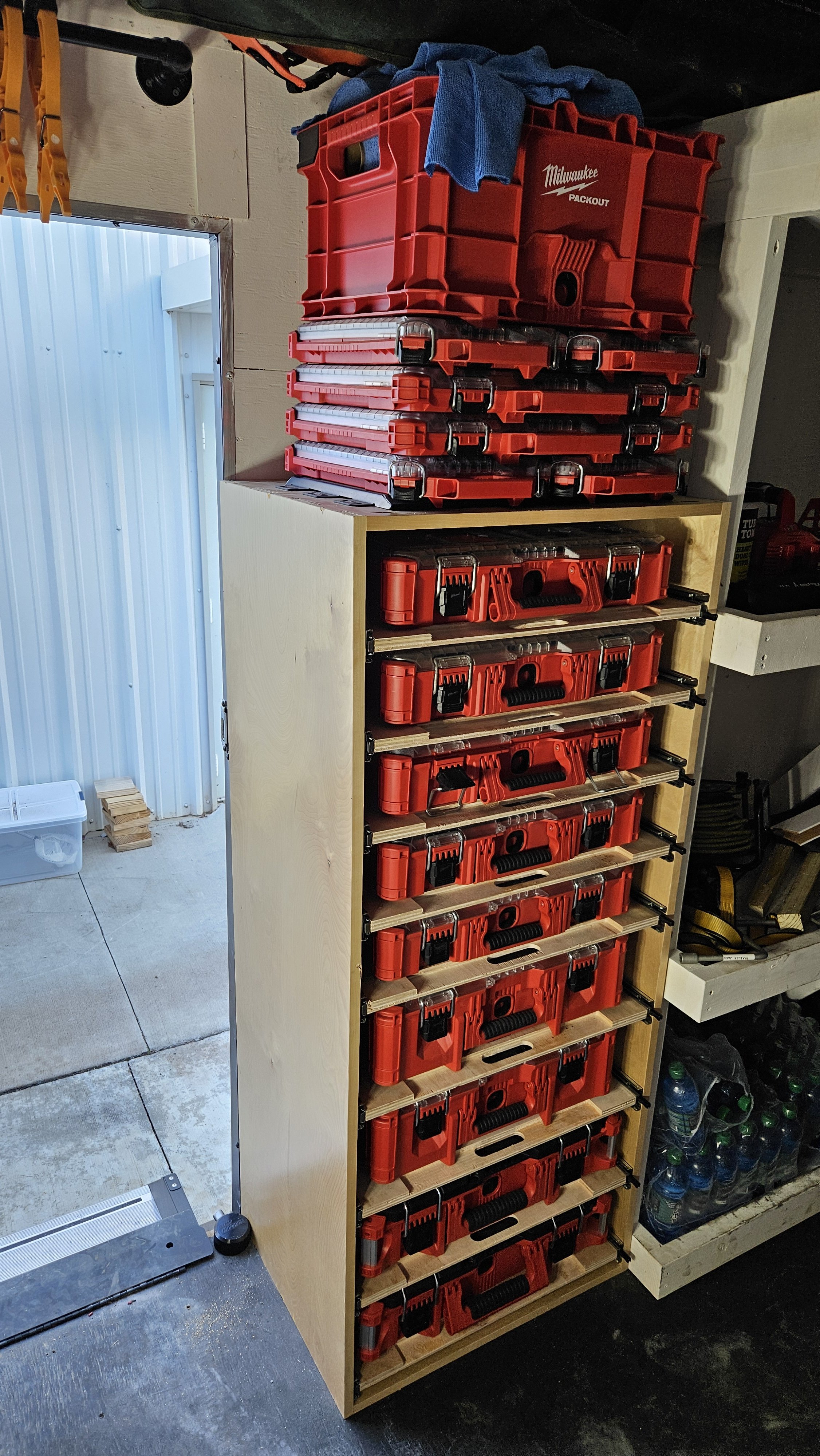 A wooden shelf with multiple red Milwaukee power tool cases stacked on top and side sections.