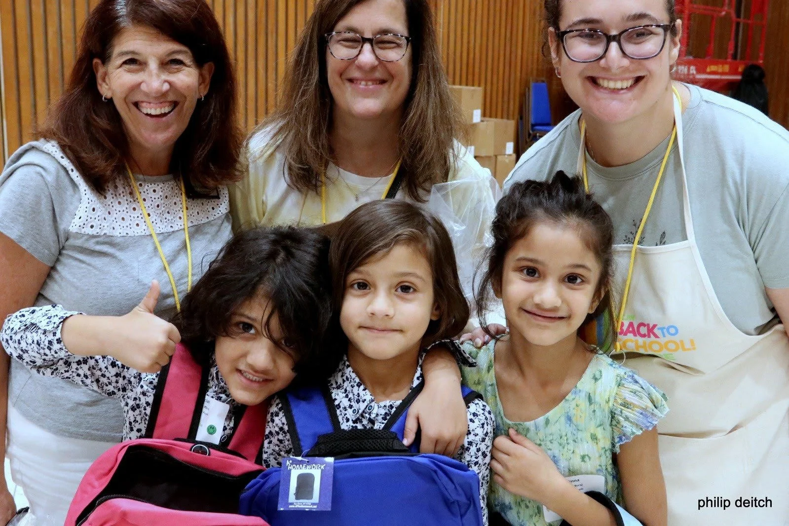 Kids and volunteers with backpacks