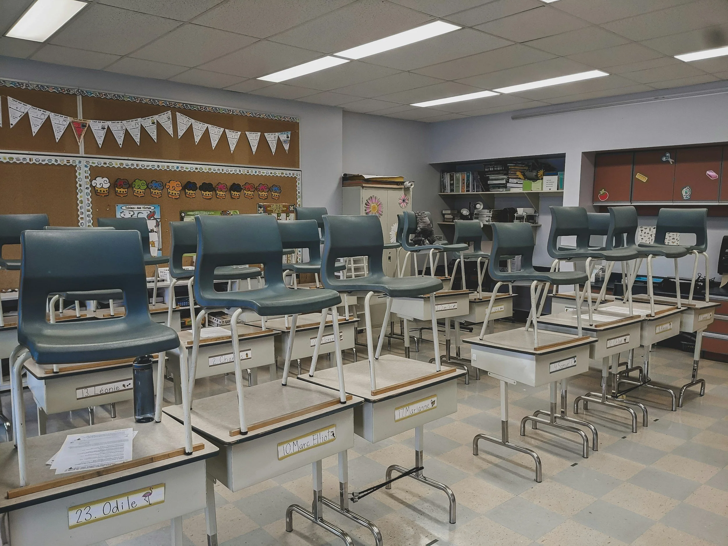 Elementary classroom with no students. Chairs are neatly stacked on desks for end of day routines.