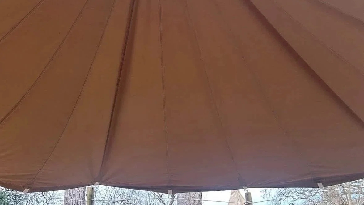 Close-up of a brown outdoor umbrella roof with visible fabric panels