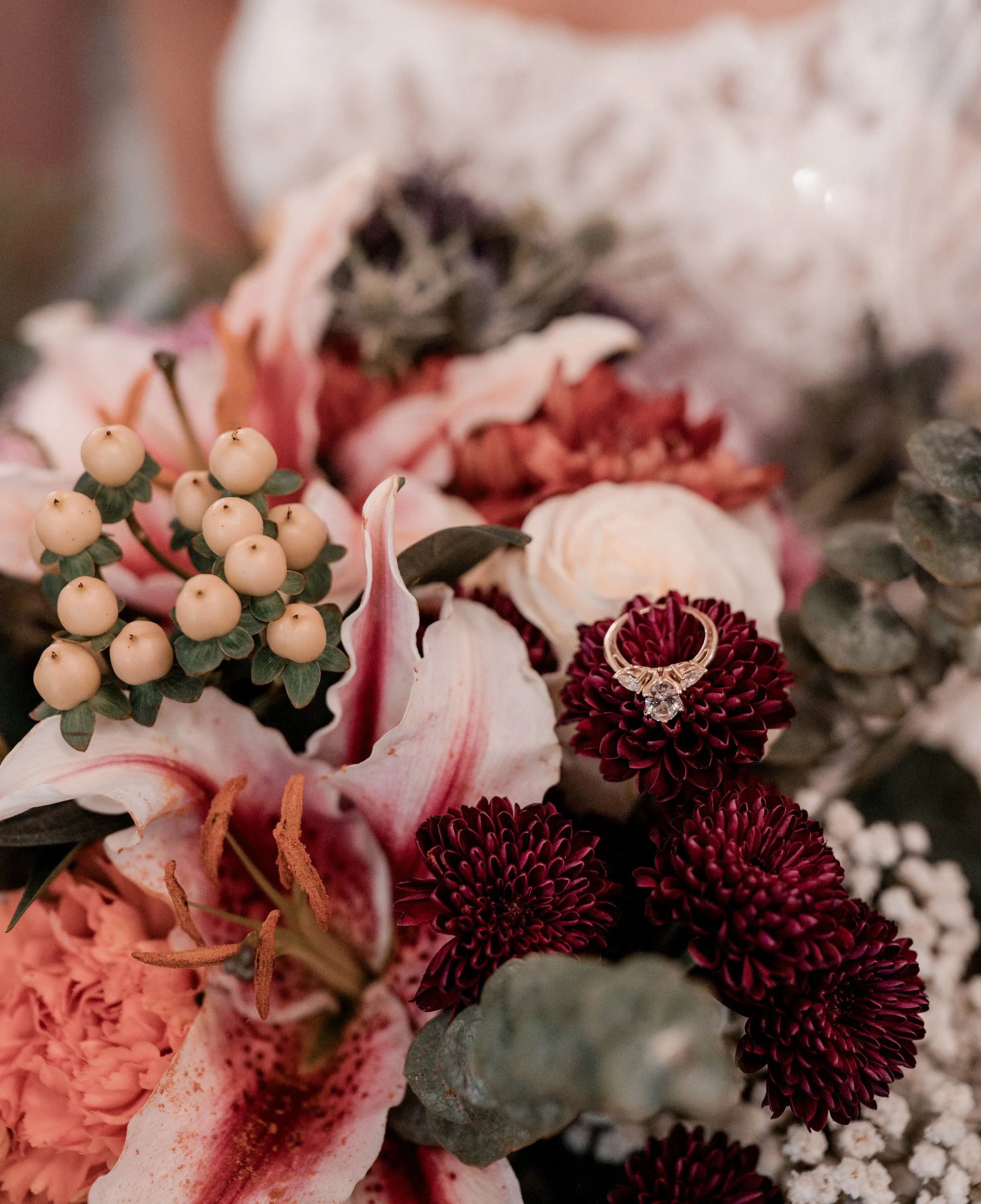 Wedding bridal bouquet with wedding ring placed on burgundy flowers pink lily's carnations babys breath greenery floral arrangement Utica Owensboro Bowling Green Henderson Kentucky Newburgh Evansville Indiana Nashville Springfield Tennessee