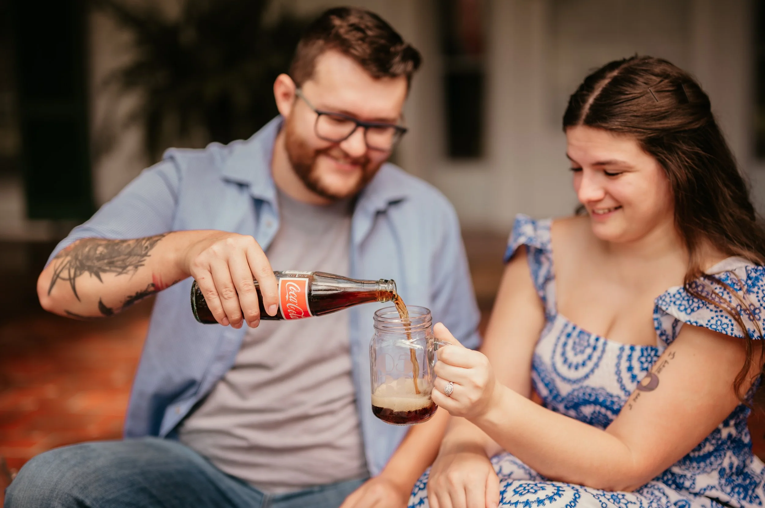 Owensboro Kentucky engaged couple photoshoot date night sharing a coke in their new engraved glass mugs with their wedding date engraved bride to be wearing a blue dress