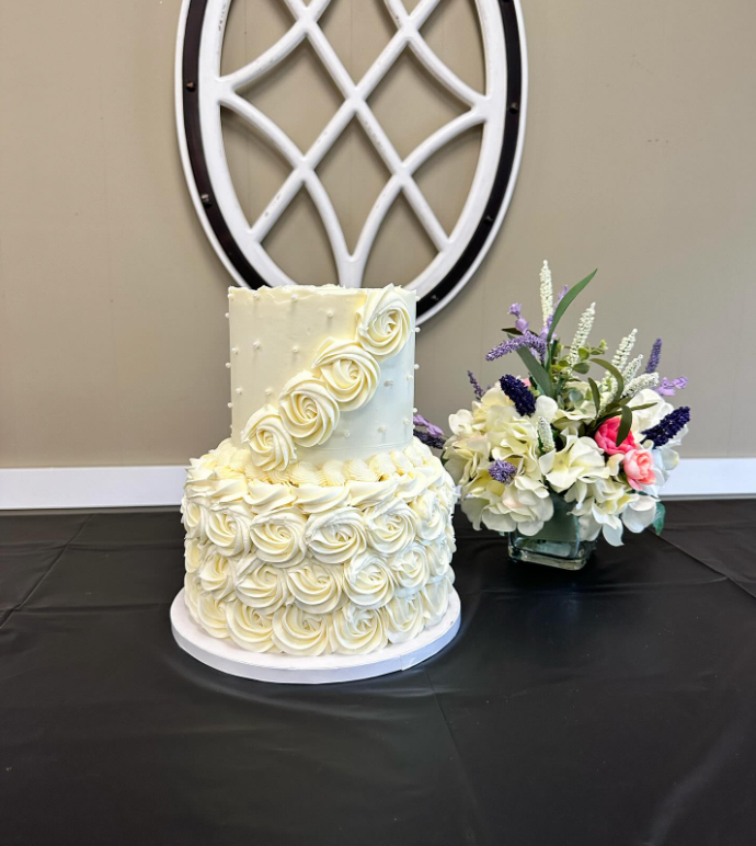 Close-up of hand-piped buttercream wedding cake with floral details