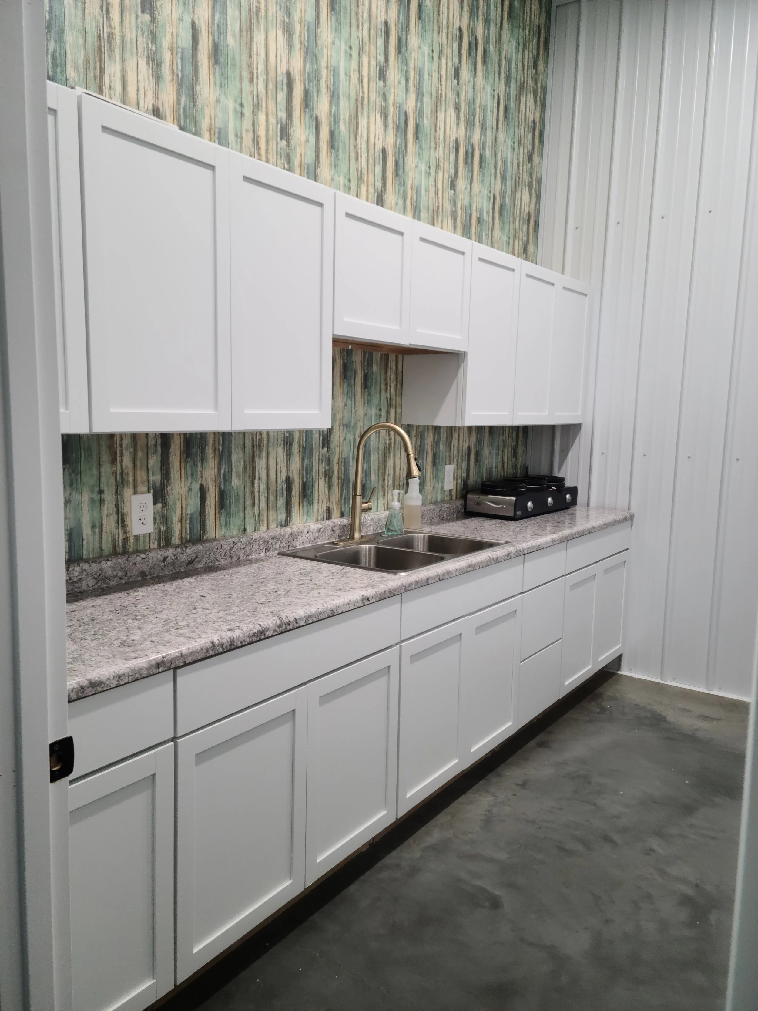 Partial Kitchen area in Kentucky wedding venue double sink counter top cabinets rustic barn wood accent wall fridge and freezer kitchenette events weddings gatherings engagements parties