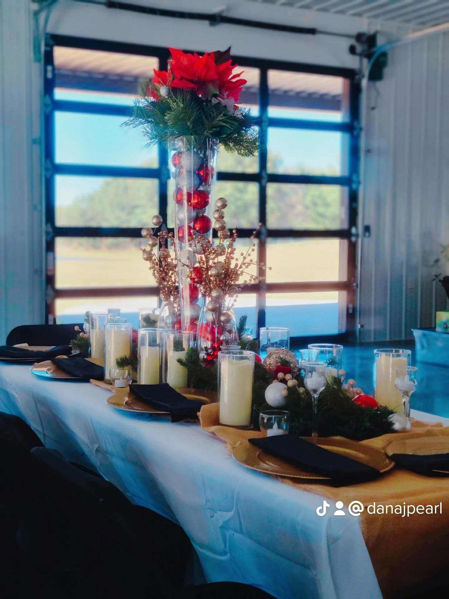 Cozy winter wedding reception at a Kentucky wedding venue Christmas theme bridal table decor engaged couple flameless candles burlap runner tealight candles gold charger plates red and gold ornaments black folded napkins white tablecloth winter time