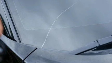 Close-up of a car's windshield with visible cracks.