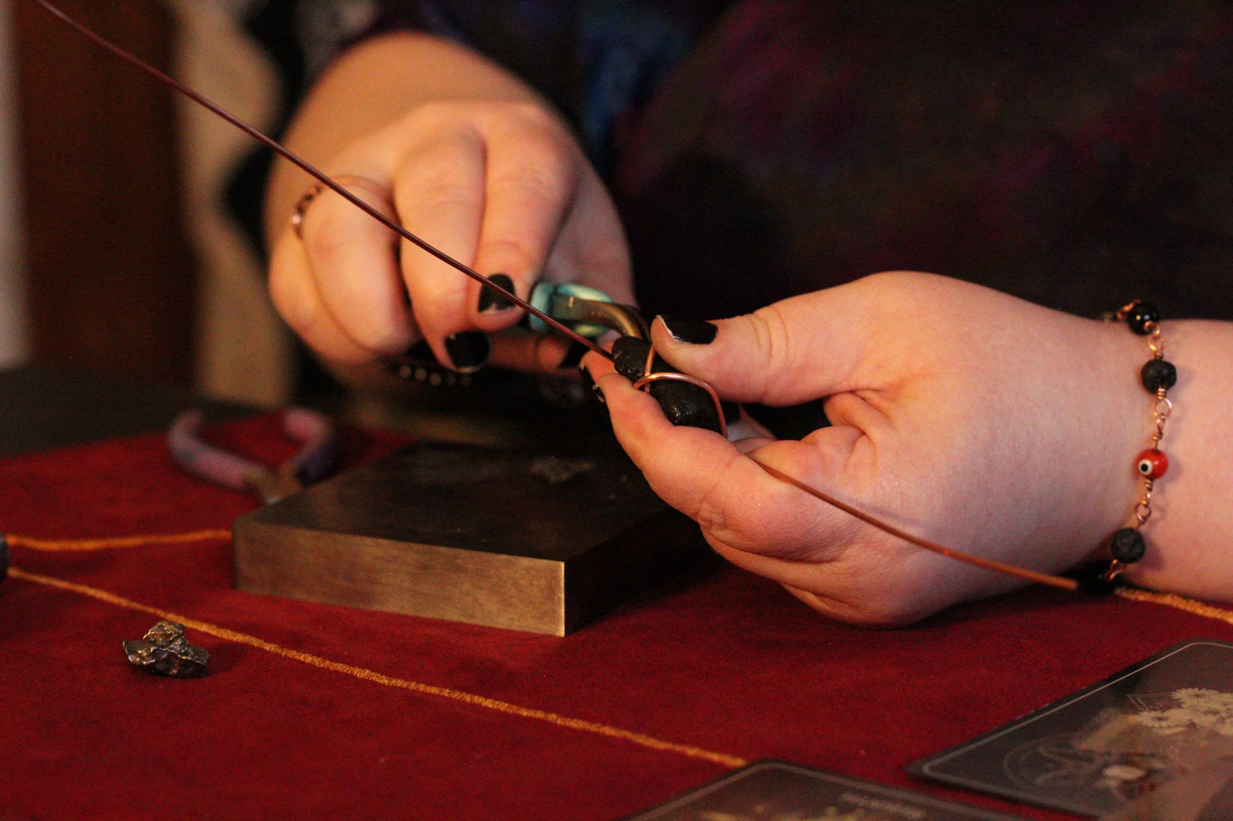 wire wrapping artist working on copper meteorite and fossil tooth photos marketing images for artists and creatives in cedar rapids iowa,
