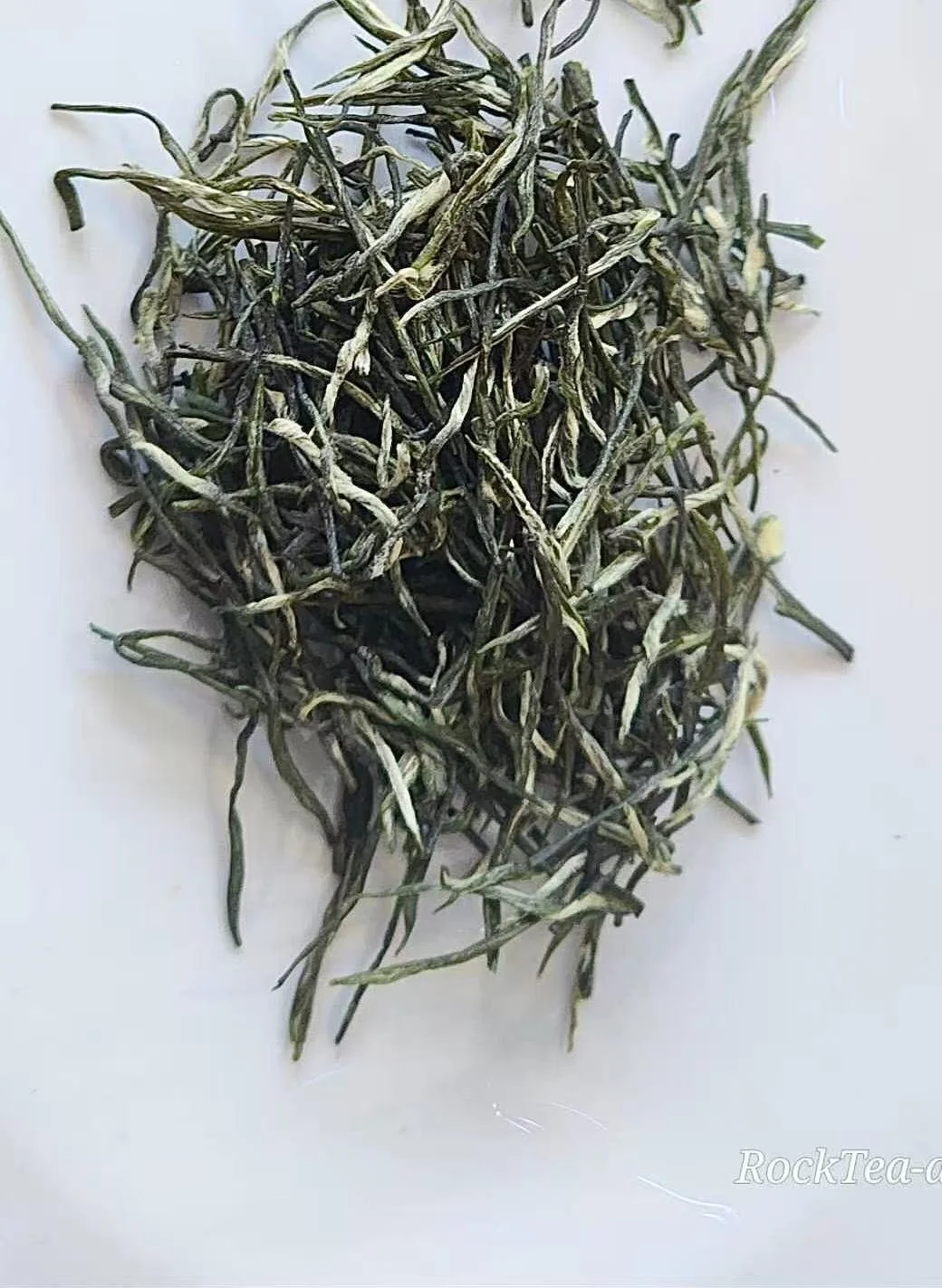 High-grade Guzhang Maojian loose leaf green tea from Thé De Roche, premium high mountain tea with visible fuzzy tips.