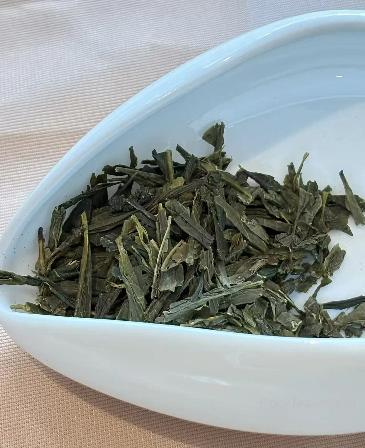 Deep green,  dry leaves of Hangzhou Sencha, crafted using traditional steaming methods.
