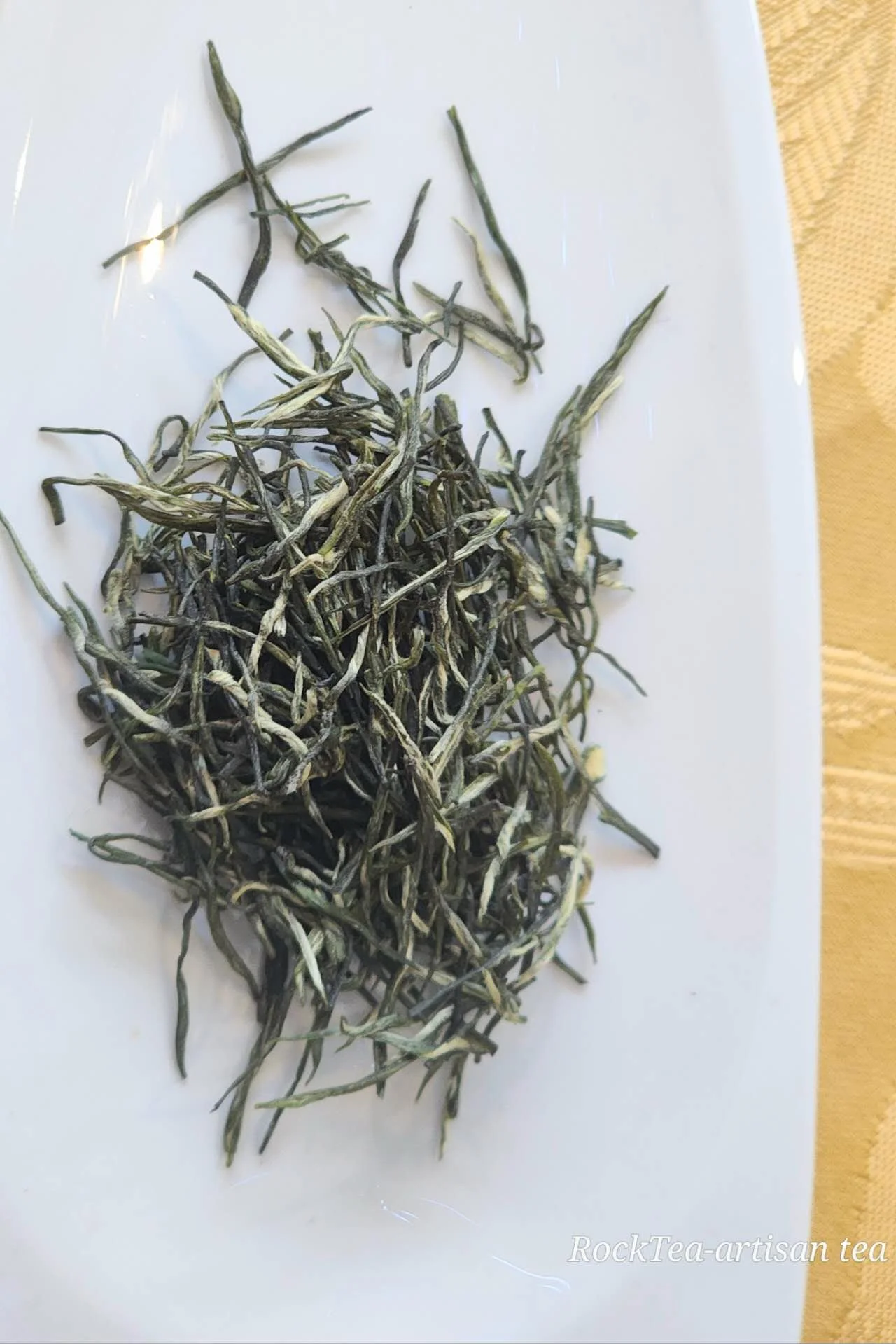 High-grade Guzhang Maojian loose leaf green tea from Thé De Roche, premium high mountain tea with visible fuzzy tips.
