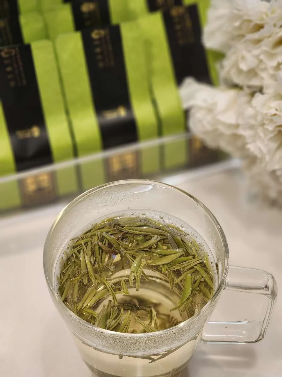 A steaming, crystal-clear bright green tea cup, emphasizing its refreshing mountain mineral aroma, sweet crisp taste.Non bitter.